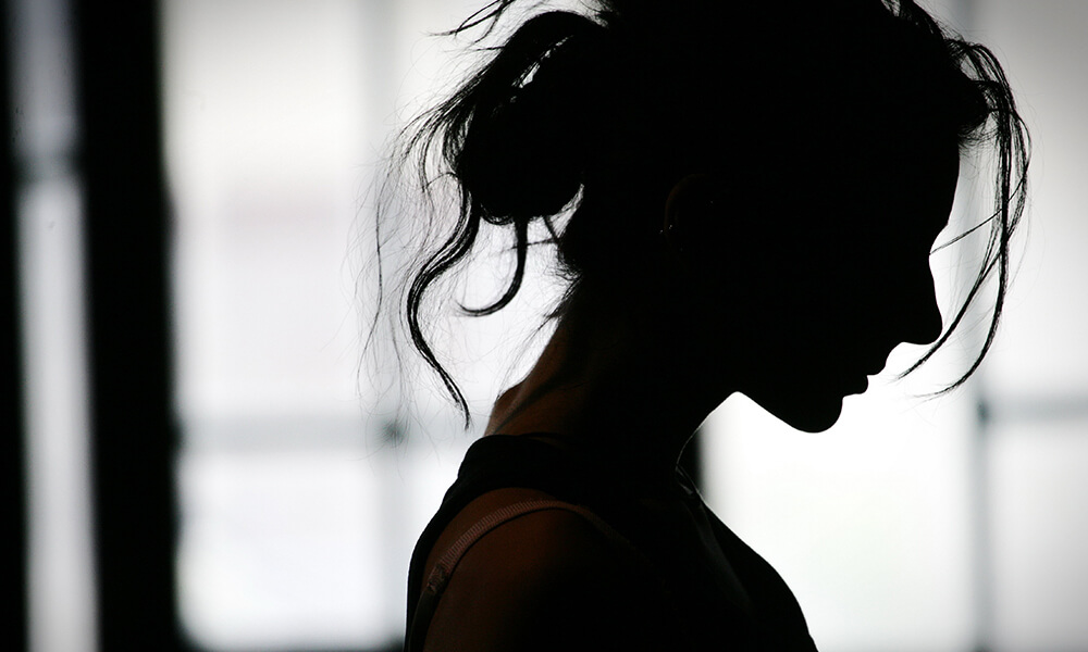 silhouette of fatigued woman with frazzled hair who feels empathy